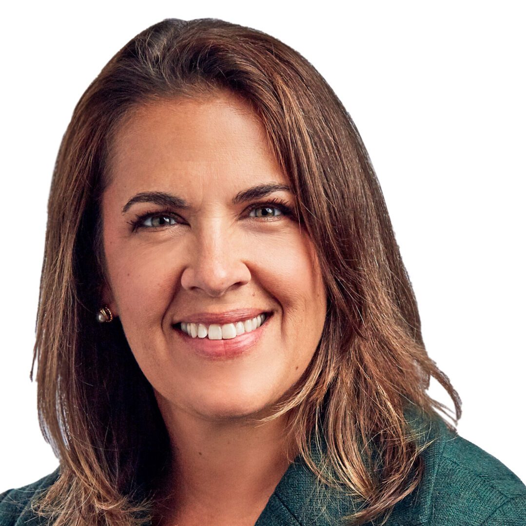 A woman with brown hair and green shirt smiling.